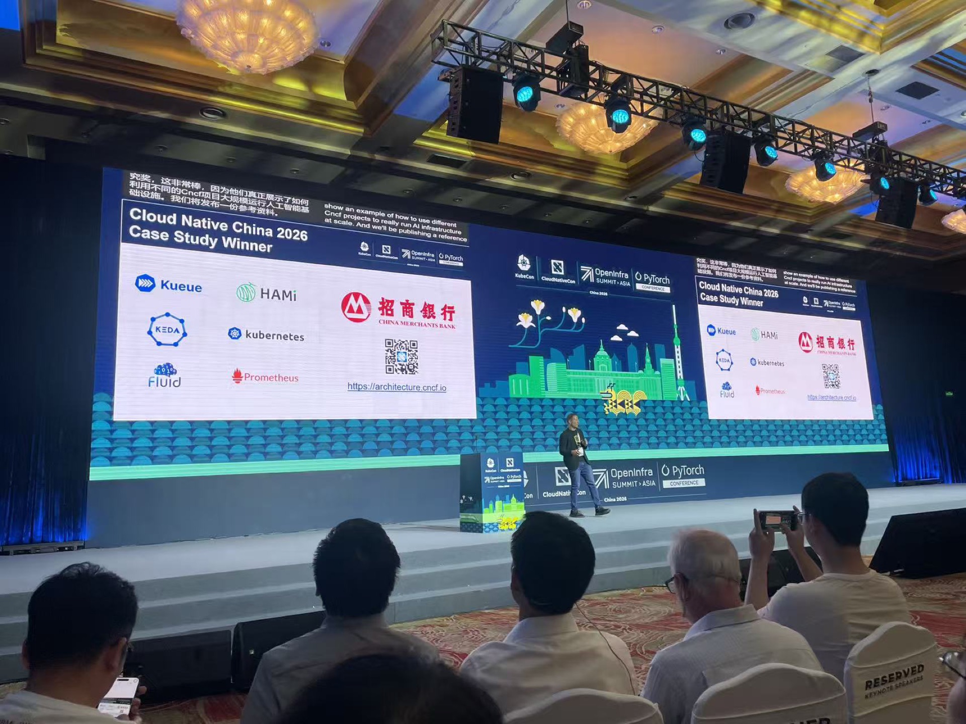 The keynote screen announcing China Merchants Bank as the Cloud Native China 2026 case study winner; its reference architecture is built on Kubernetes, Kueue, KEDA, Fluid, Prometheus, and HAMi